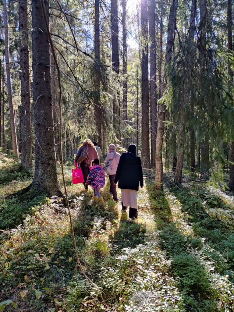 ihmisiä kävelee metsässä