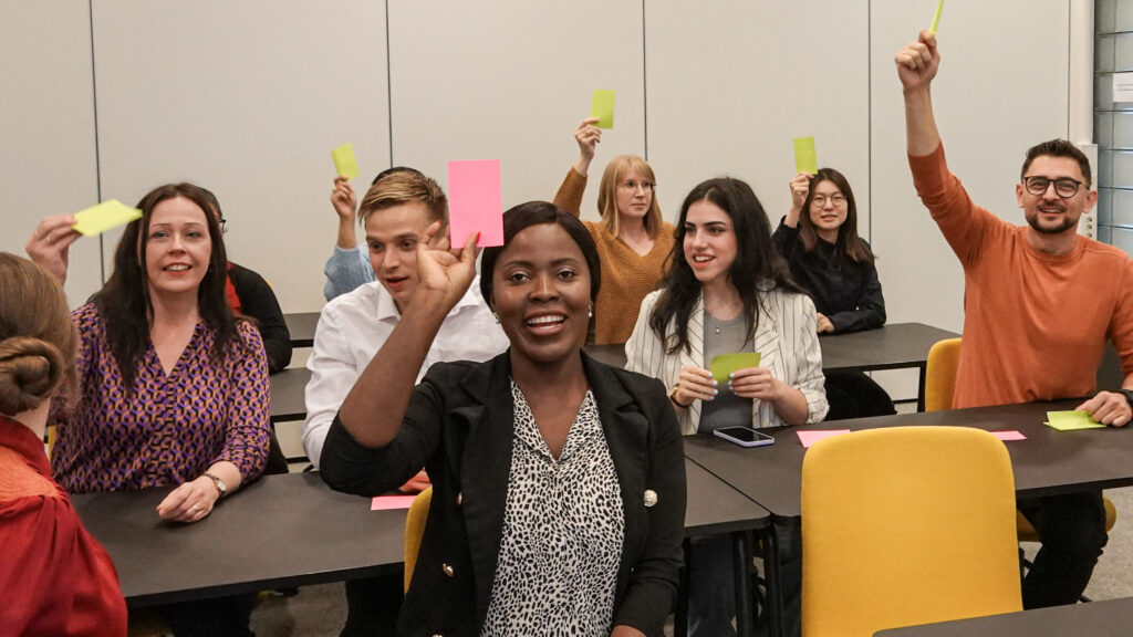 Joukko eri taustaisia ihmisiä äänestää lappuäänestyksellä