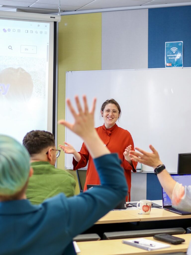 Julie Breton teaching and smiling in front of a whiteboard
